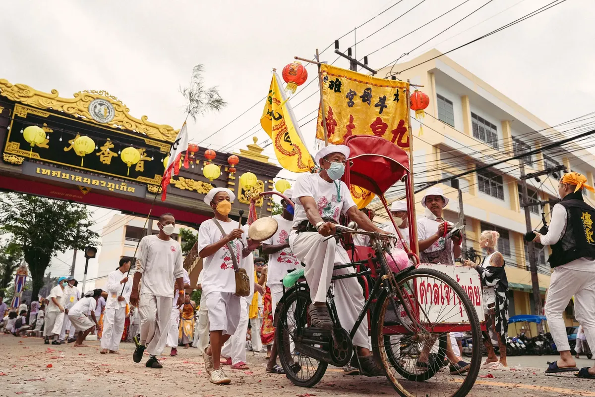 Colorful street parade in Phuket celebrating a traditional festival.