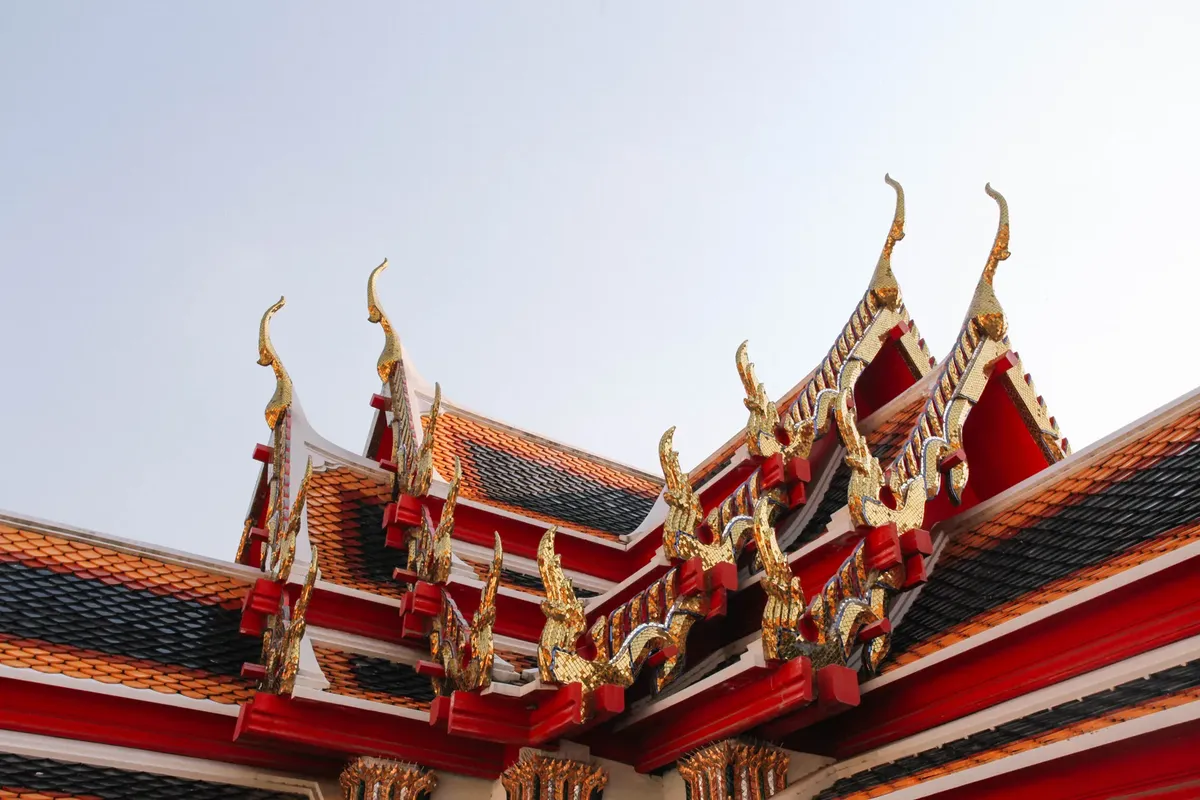 Captivating view of traditional Thai temple roof with ornate details in Bangkok, Thailand.