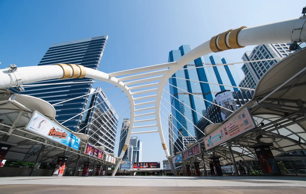 Futuristic cityscape featuring the iconic skywalk and skyscrapers in Bangkok, Thailand.
